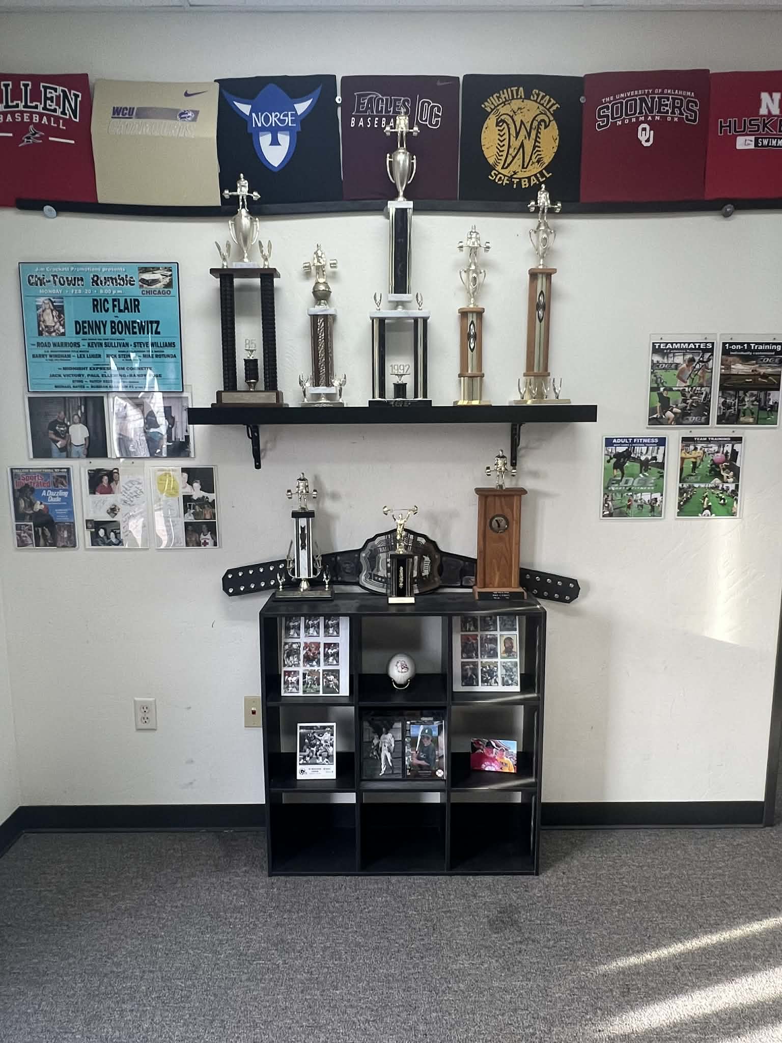 Championship trophies and team pennants on display at the Edmond athletic training facility