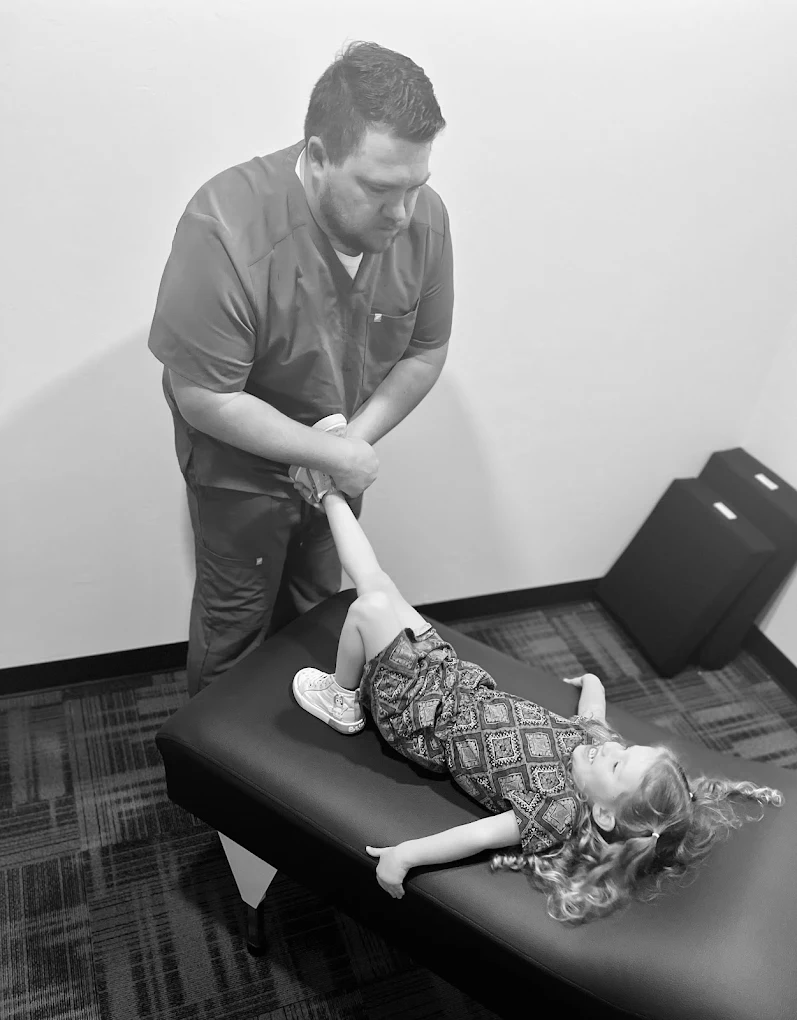 A child receiving a gentle, low-force pediatric adjustment at REVIVE