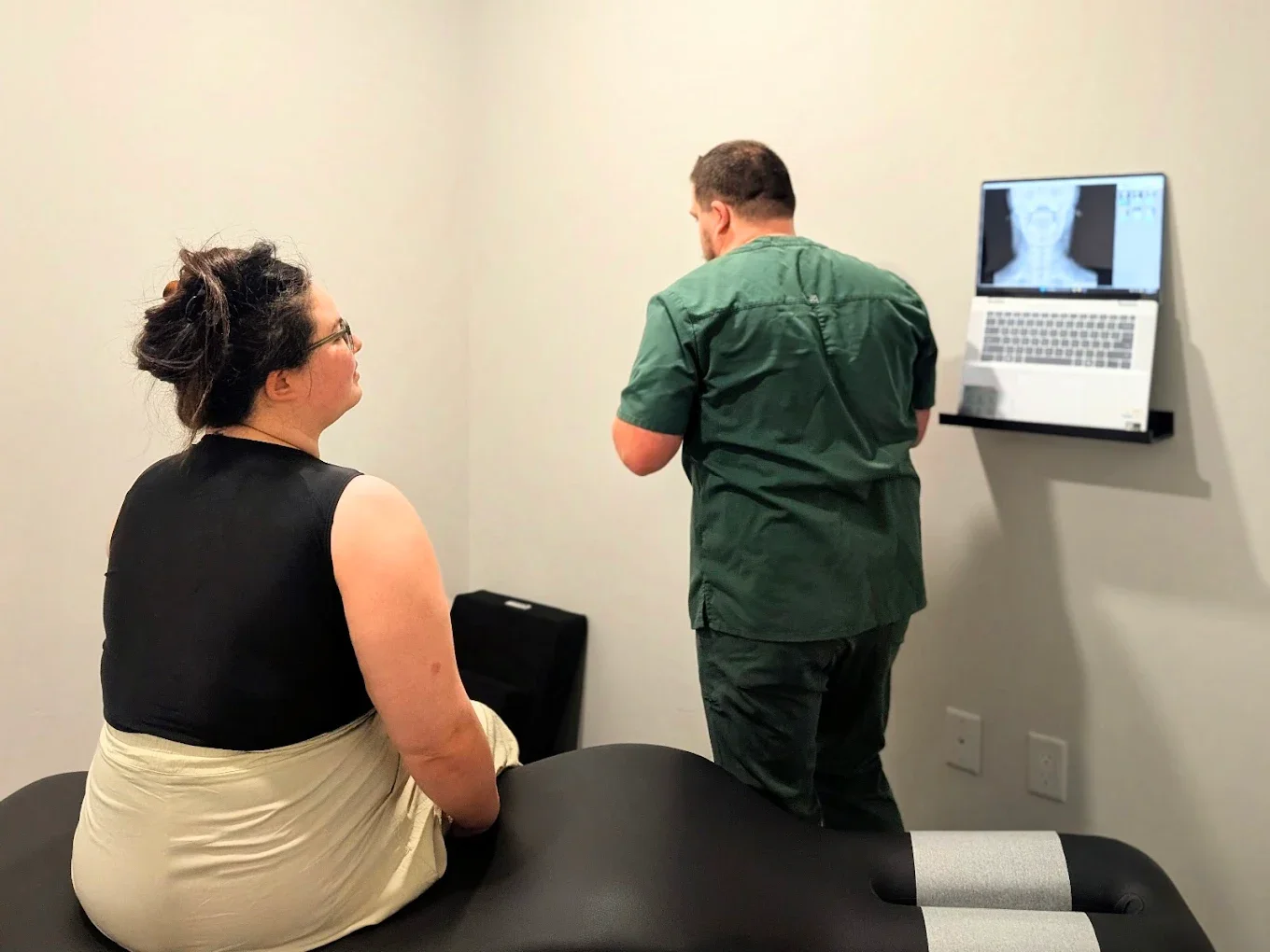 Dr. Jake Edwards explaining X-ray findings to a patient at REVIVE